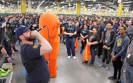 Amazon employees are cheered on Tuesday by co-workers and managers as they walk the orange carpet into the new Kent fulfillment center for their first day of work in the new building. The day started with the new Amazonians on the orange carpet and attending safety school.