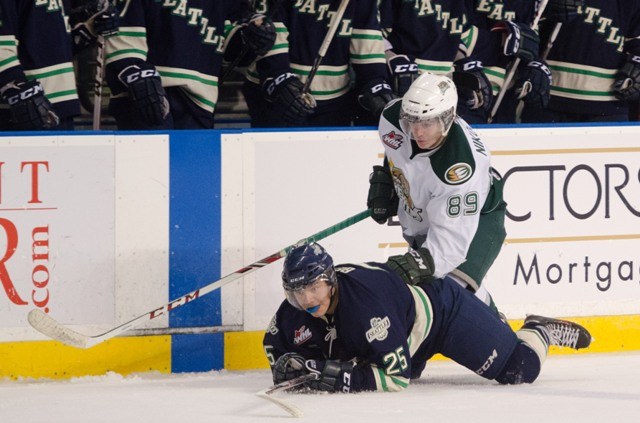 The Thunderbirds' Ethan Bear falls to the ice while battling the Silvertips' Ivan Nikolishin.