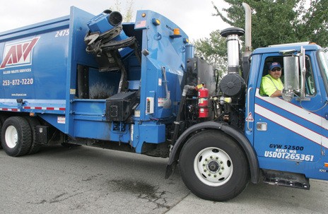 Allied Waste Services' driver John Egan Jr. demonstrates how the truck picks up a recycling bin in this 2009 photo. Kent residents will see many changes in garbage and recycling services starting April 1 under a new city contract with Allied.