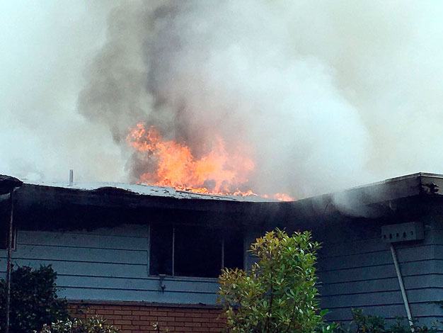 Fire burns through a roof at an abandoned home Monday in Kent in the 23500 block of 98th Avenue South.