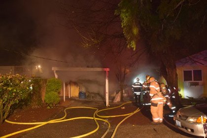 Kent firefighters douse a single-story house fire in the 24900 block of Military Road South early Sunday morning.