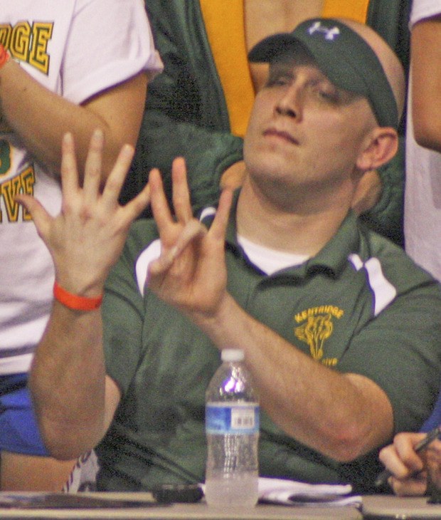 Bridging the language barrier: Coach Mike Dobner signs to his swimmers during the state championships.