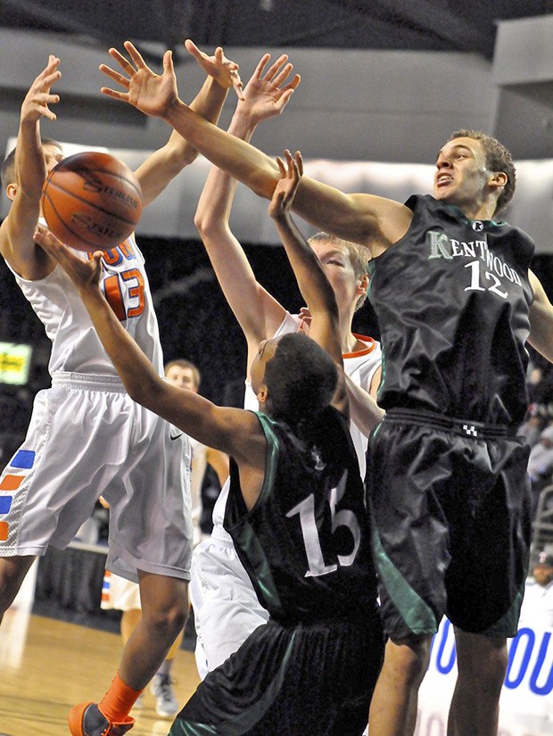 Kentwood's Preston White (15) and Terrence Grady (12) battle Auburn Mountainview's Robbie Wilson (13) for possession.