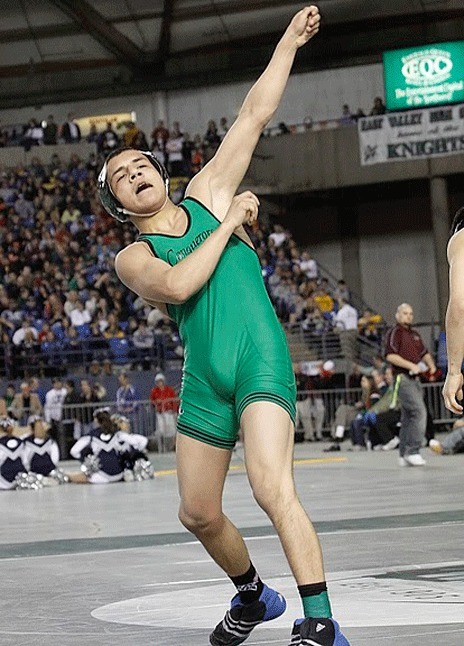 Kentwood High senior Ruben Navejas follows through with a right-handed swing after beating Evergreen's Matthew Nguyen 8-3 for the 112-pound state championship Saturday night. It was Navejas' second state title