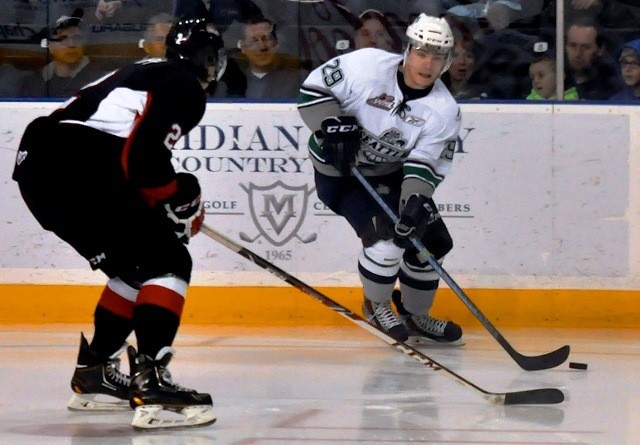 The Thunderbirds' Roberts Lipsbergs looks to pass the puck in front of Cougars defenseman Sam Ruopp.