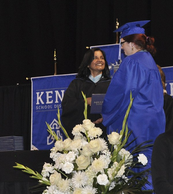 Kent School Board member Maya Vengadasalam hands a diploma to Melissa Quitoriano