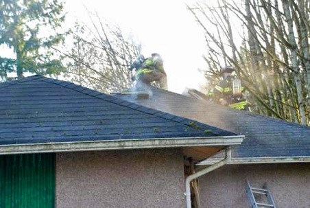 Firefighters cut a hole in the roof to let smoke escape and to gain access to the attic fire Thursday