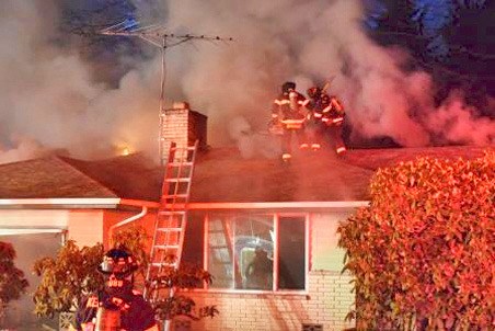 Kent firefighters ventilate a house Wednesday evening in the 26100 block of 145th Avenue Southeast by cutting holes in the roof. Crews put out the fire in about 30 minutes.