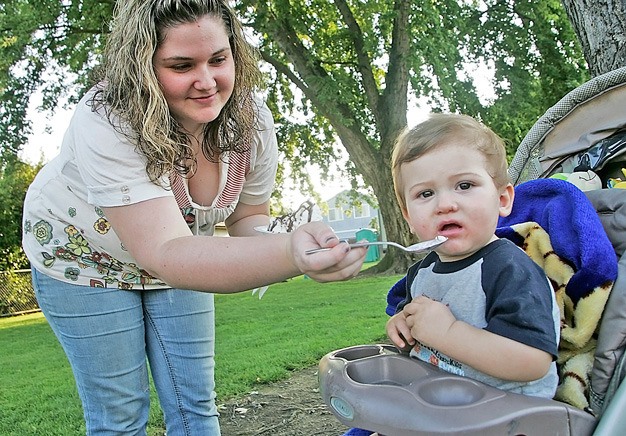 Dawnielle Hand feeds her son a bite of ice cream at the North Park neighborhood's National Night Out event in Kent last summer. Neighborhoods can register now for the 2011 event.