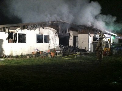 A fire fighter surveys the damage done to a residential home which caught fire Dec. 3. The fire was caused by a power strip.