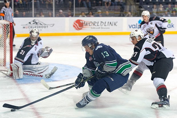 The T-Birds' Mathew Barzal beats the Giants' Ben Thomas to the puck in front of Vancouver goalie Ryan Kubic.