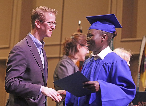 Cadet Mana Gach of Kent shakes hands with Congressman Derek Kilmer during commencement in Bremerton on Dec. 19.