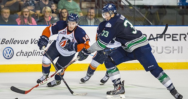 The Thunderbirds' Jared Hauf advances the puck with the Blazers' Matt Needham in pursuit.