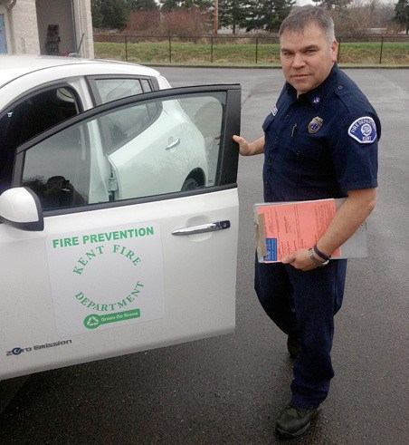 Kent Fire Department Capt. Phil Herrera shows off the new Nissan Leaf and its distinct door logo.