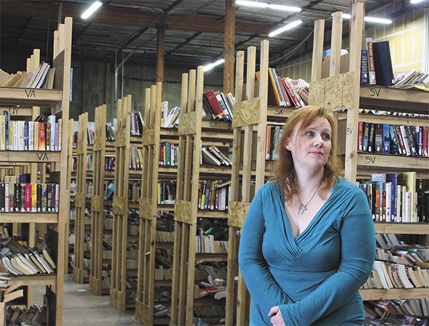 Grim ending: Carrie Devault  stares off at the multiple shelves of books in her bookstore.