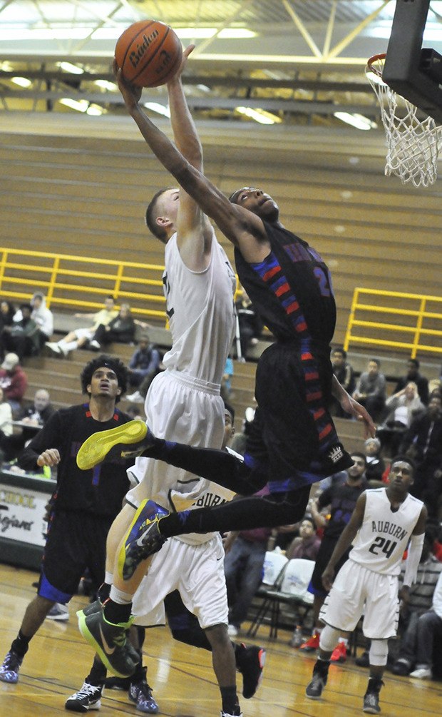 Kent-Meridian's Nate Barton goes up for a shot as Auburn's Gavin Strojan goes for the block during Wednesday night's game.