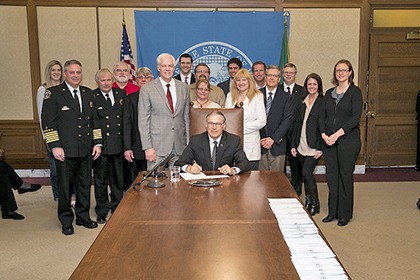 Gov. Jay Inslee signing Rep. Mark Hargrove’s emissions-reduction legislation on March 27.