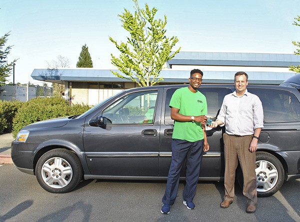 Councilmember Dave Upthegrove presents the keys to a surplus King County van to G.E.M. co-founder and president Kendrick Glover. The mentoring organization will use the vehicle transport young men to weekly group meetings and educational events.