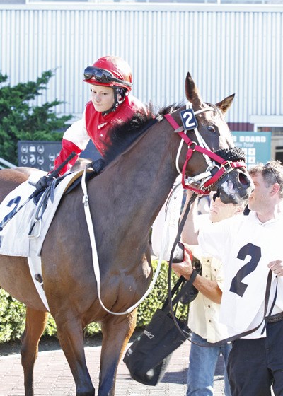 Jockey Elizka Zubinova is given a leg up Saturday on Sassy Britches by trainer Dan Kenney for her first professional ride in America at Emerald Downs. Sassy Britches finished sixth