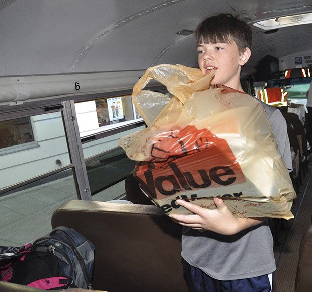 A student brings schools supplies to help Communities In Schools of Kent fill a bus with donations Thursday.