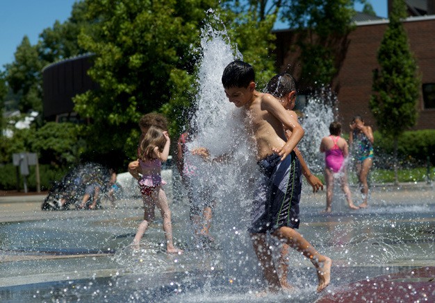 Kids play on a recent hot day at Kent's Town Square Plaza fountain.