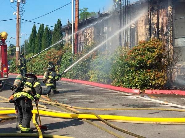 Firefighters work to extinguish a fire late Monday afternoon at Kent-Meridian High School.