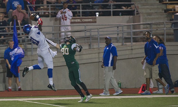 Kent-Meridian's Emmanuel Daigbe snags a pass over Kentridge's Matt Fleming during Friday night's game at French Field. Daigbe caught five passes