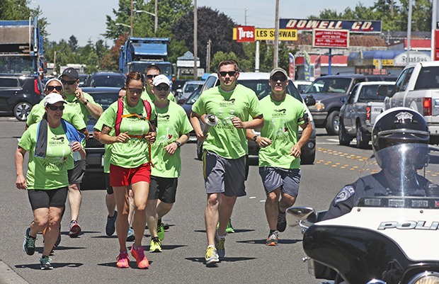 Kent Police officers run along Central Avenue North during the Special Olympics' Flame of Hope Torch Run on Friday afternoon.