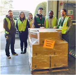 Associates from Amazon’s Sumner fulfillment center stand next to their donation to the Kent Food Bank. The associate-coordinated food drive donated nearly 2