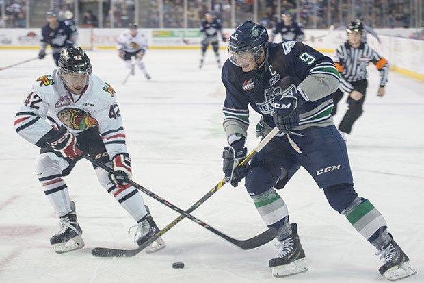 Portland's Layne Viveiros battles Seattle's Justin Hickman for the puck during WHL action Saturday night.