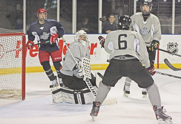 Grey Team goalie Bobby Gathercole eyes the puck after deflecting a shot during last week Thunderbirds’ scrimmage at the ShoWare Center.