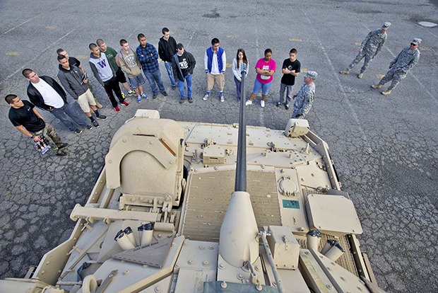 Students from several school groups listen to a National Guard staff sergeant explain the M3 Bradley Fighting Vehicle.