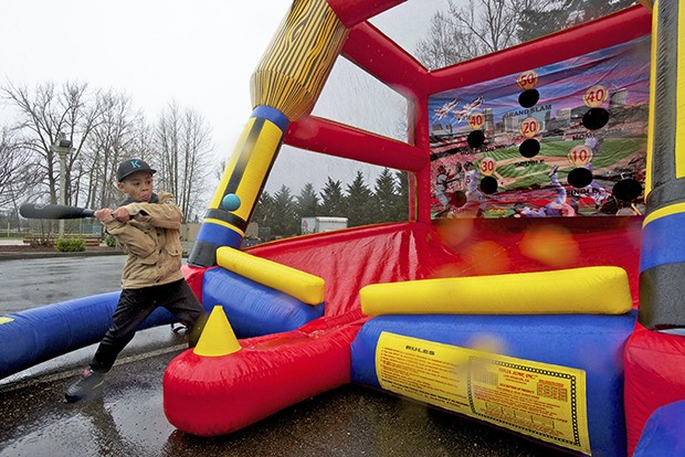 Marcus McIntyre takes a swing at one of the open booths during Kent Little League's official season-opening weekend.