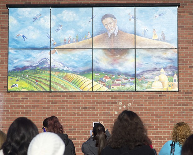 Bystanders stop to admire the new mural outside of  St. Vincent De Paul on Central Avenue on Wednesday.