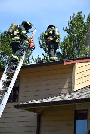 Firefighters work to douse a fire that severely damaged a condo unit in Kent on Saturday. No one was injured in the fire.