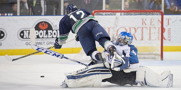 Kootenay goalie Wyatt Hoflin upends Seattle's Ryan Gropp as he fires a shot during WHL play Saturday night.