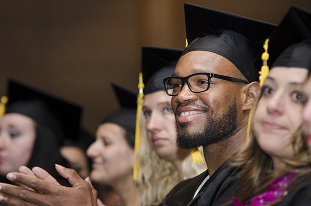 Kent's Brandon Hoggans applauds during Marylhurst University's commencement ceremonies.