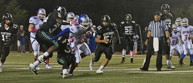 Kentwood chases down Kent-Meridian receiver Marc Dennis during the SPSL showdown between the schools last Friday night at French Field. Kentwood won 38-7.