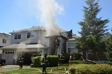 Firefighters attack a blaze Wednesday at a Kent home in the 22200 block of 129th Place Southeast.