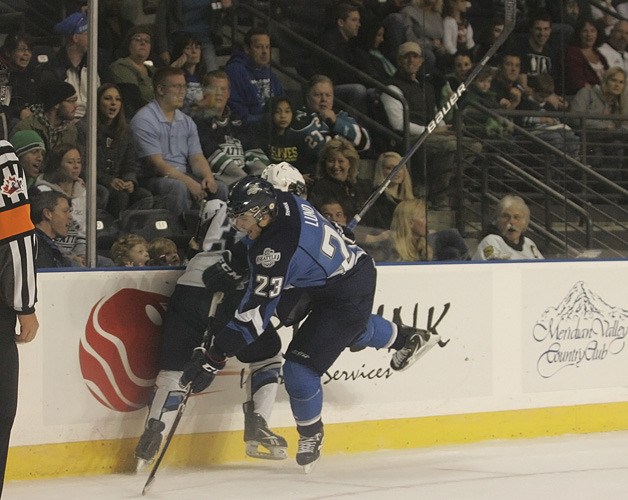 Seattle Thunderbird Chance Lund crushes Blades' Kyle Hass into the dasherboards