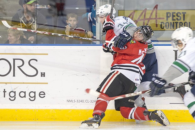 The Thunderbirds' Luke Osterman tangles with the Winterhawks' Skyler McKenzie during WHL play Saturday night at the ShoWare Center.