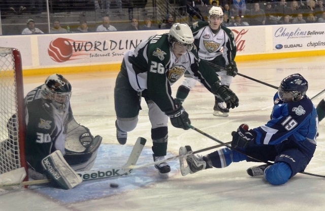 Seattle’s Riley Sheen tries to push the puck past Everett goalie Austin Lotz as Cole MacDonald defends.