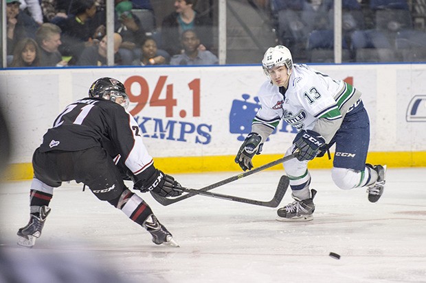 Seattle's Mathew Barzal pushes the puck up the ice with Vancouver's Brennan Menell defending.