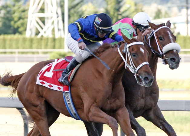 Talk to My Lawyer (No. 1) and jockey Leslie Mawing pass Havanna Red and Leonel Camacho-Flores in the 74th running of the Gottstein Futurity on closing day at Emerald Downs.