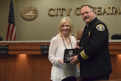 Kent Fire Deputy Chief Brian Wiwel presents Cheri Dreiling with the Outstanding Citizen Community Service Award.