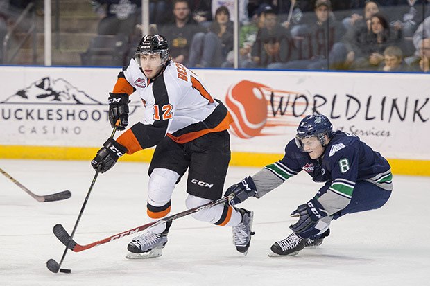 Medicine Hat's Kyle Becker pushes the puck up the ice with Seattle's Scott Eansor defending.