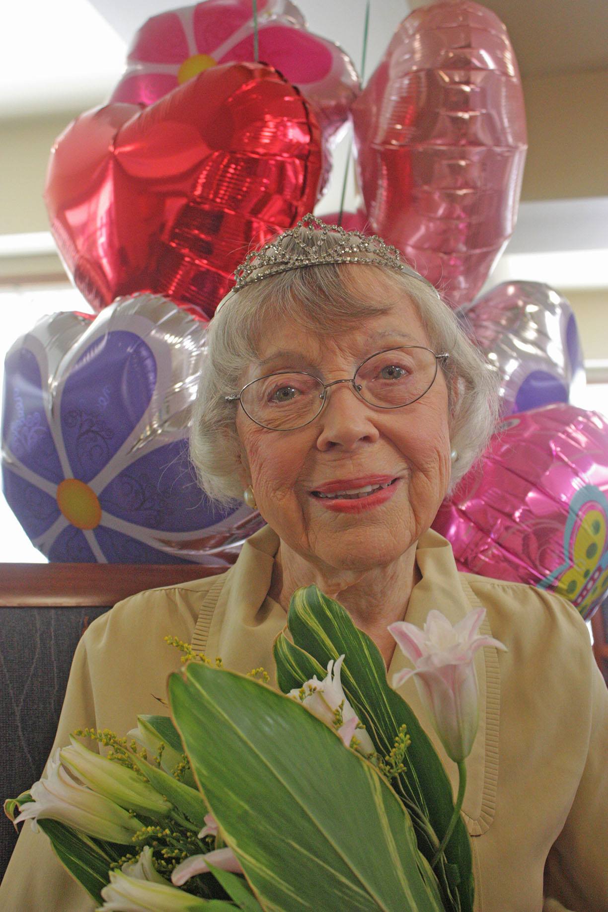 Kent’s Yvonne Monroe is graced with flowers and balloons at her 100th birthday party last Friday at the Harrison House