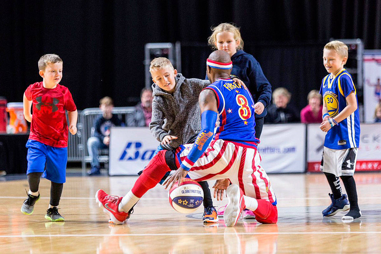 Firefly of the Harlem Globetrotters keeps the ball away from children on Tuesday at the accesso ShoWare Center in Kent. COURTESY PHOTO, @dcongerphoto