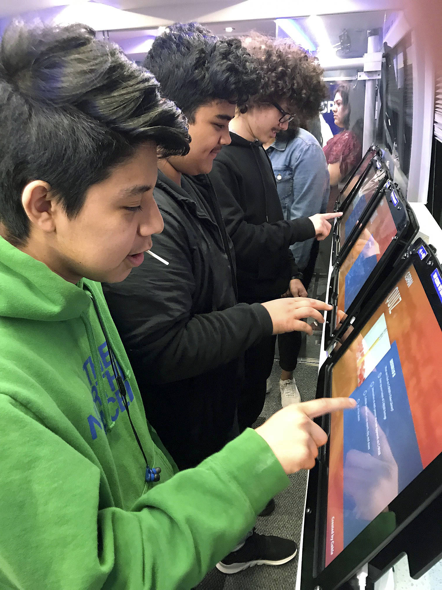 Students interact with large-screen tablets on the high-tech C-SPAN Bus during its stop at Kent-Meridian High School on Friday. MARK KLAAS, Kent Reporter