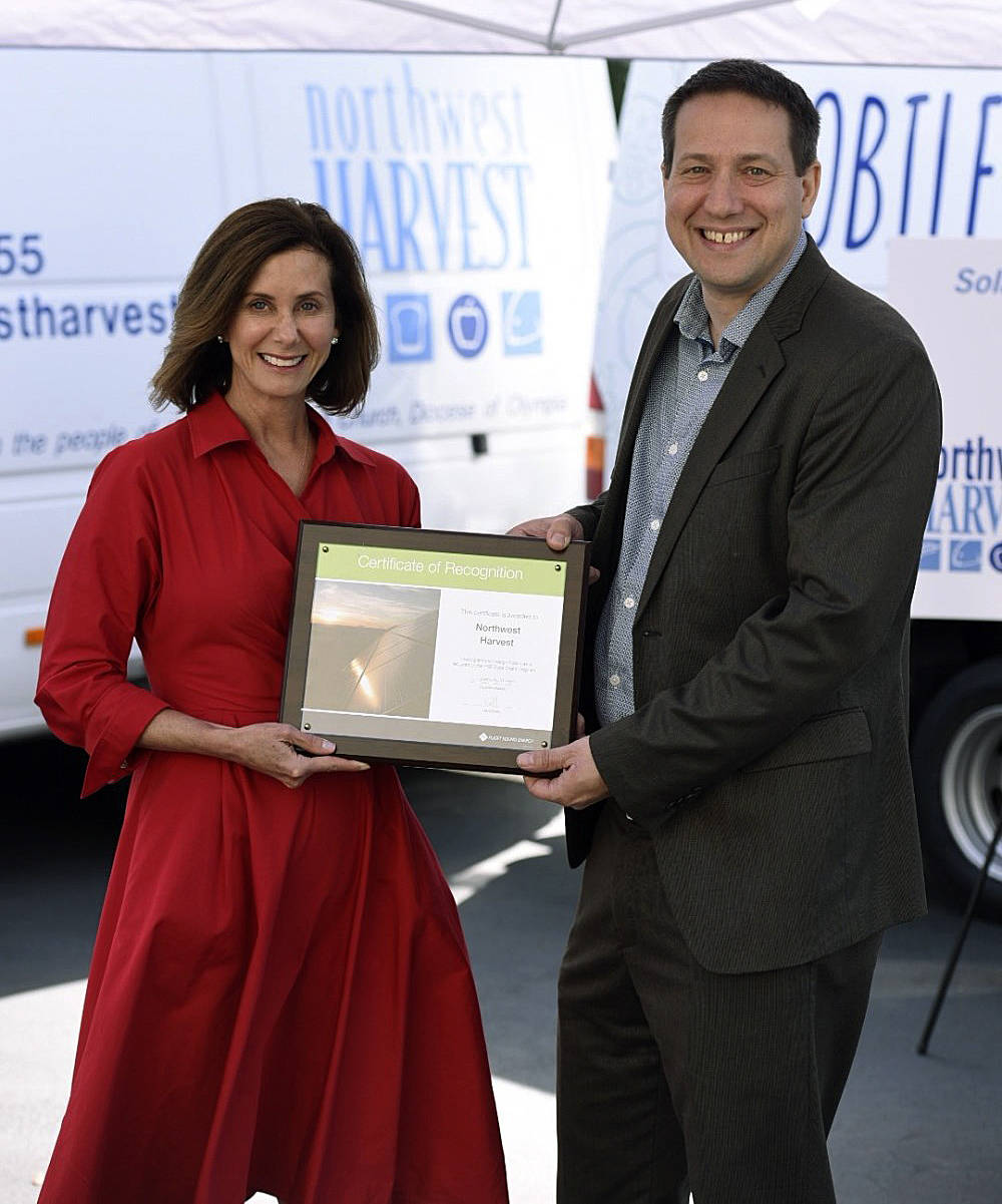 PSE President and CEO Kimberly Harris presents a plaque to Northwest Harvest CEO Thomas Reynolds. COURTESY PHOTO